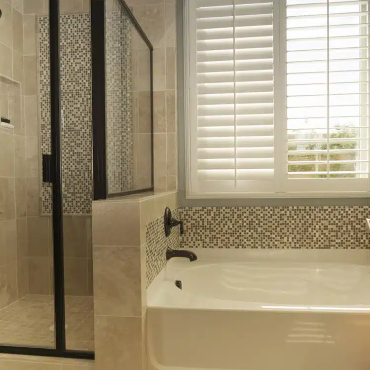 beautiful bathroom window with composite plantation shutters installed by IWS for privacy in the bathroom