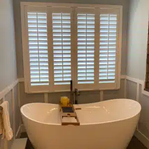 beautiful bathroom window with custom plantation shutters installed by IWS for privacy in the bathroom
